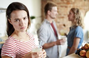 woman staring away from guy and girl talking, she appears jealous.