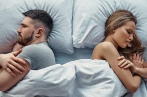 couple not facing each other in bed, look angry