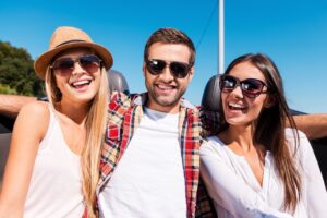 happy open relationship with one guy and two women in sunshine smiling