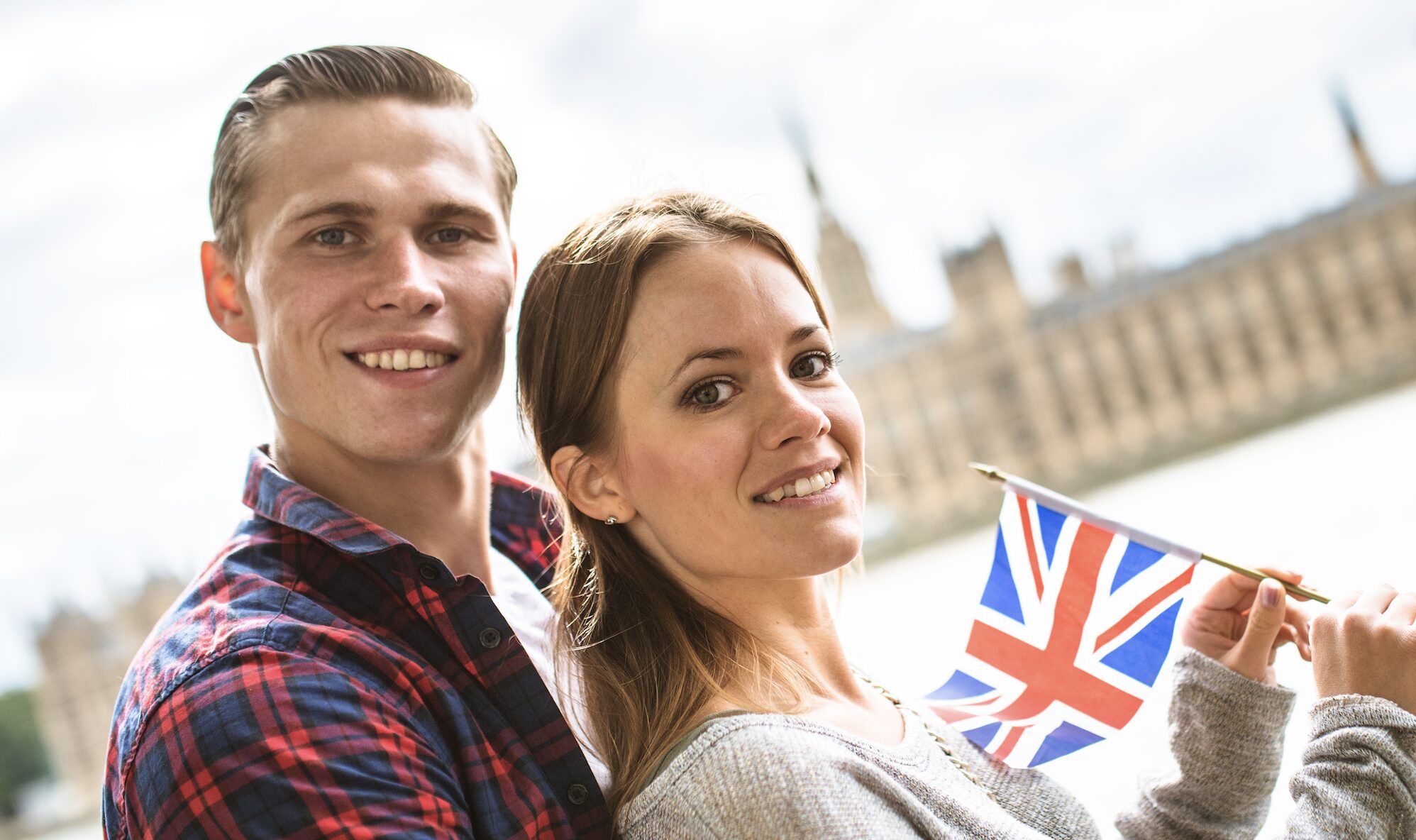 couple holding UK flag in front of Big Ben