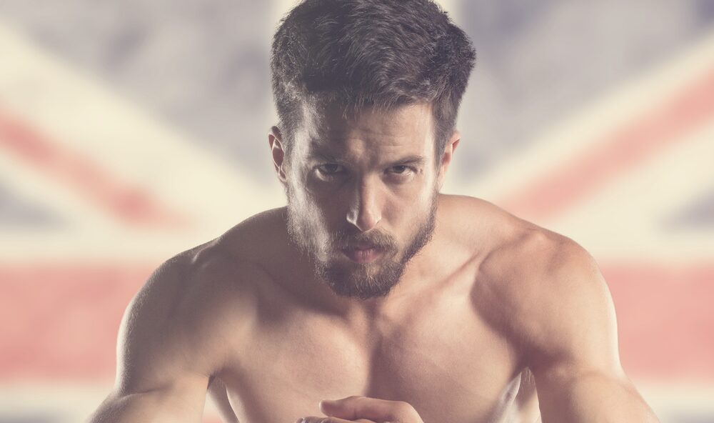 muscular man in front of blurred UK flag