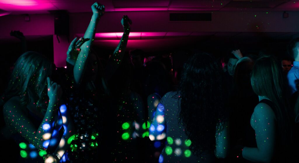 Greedy girls party at a UK swingers club – couples and single women socialising and dancing at the bar