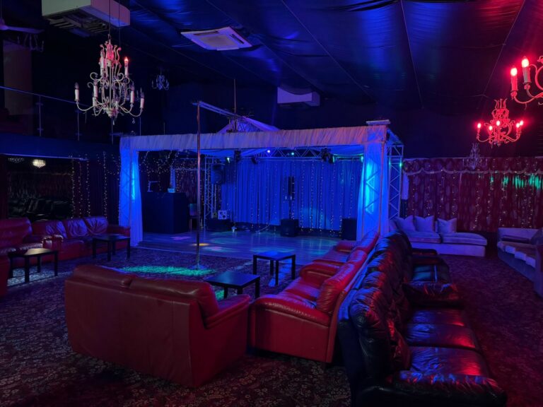 Interior of the club Pandora in Leeds, Armley, showing red leather sofas, stage with lights, dancing pole and dancing floor